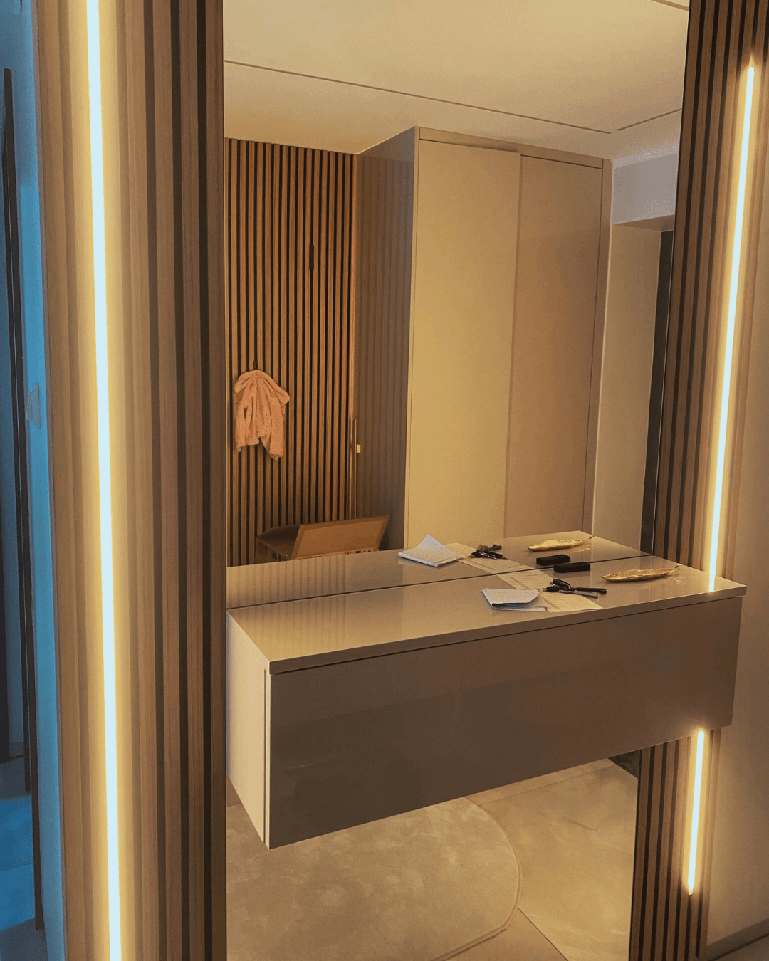 Flur mit Akustikpaneelen und einem Spiegel mit einem hängenden Sideboard