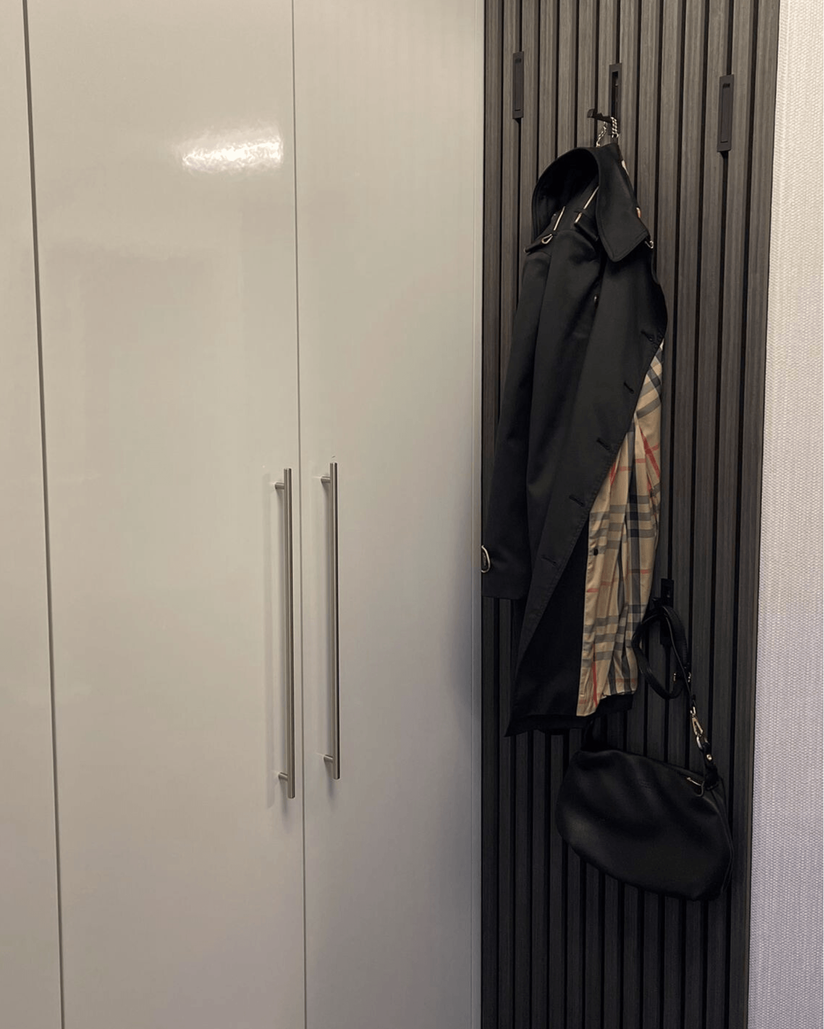 Flur mit schwarzen Akustikpaneel Garderobe und klappbaren Garderobenhaken 