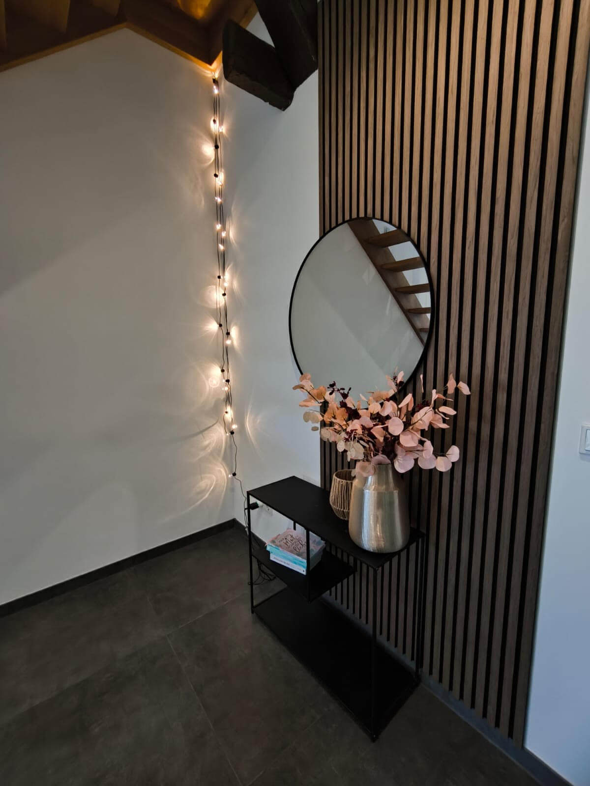 Wohnzimmer mit Akustikpaneelen in Walnuss und einem Spiegel 